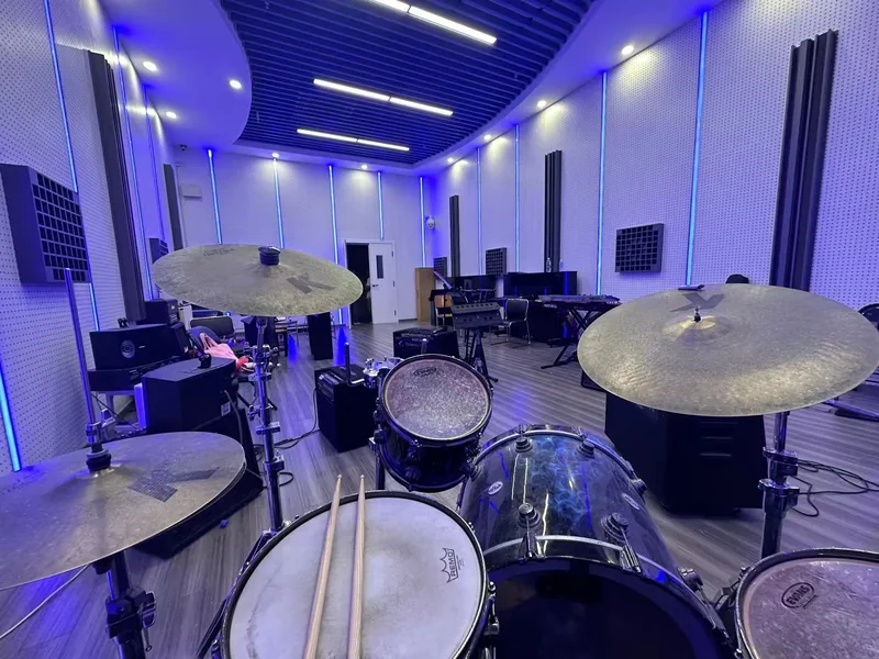 A drum kit in a blue-lit rehearsal room.