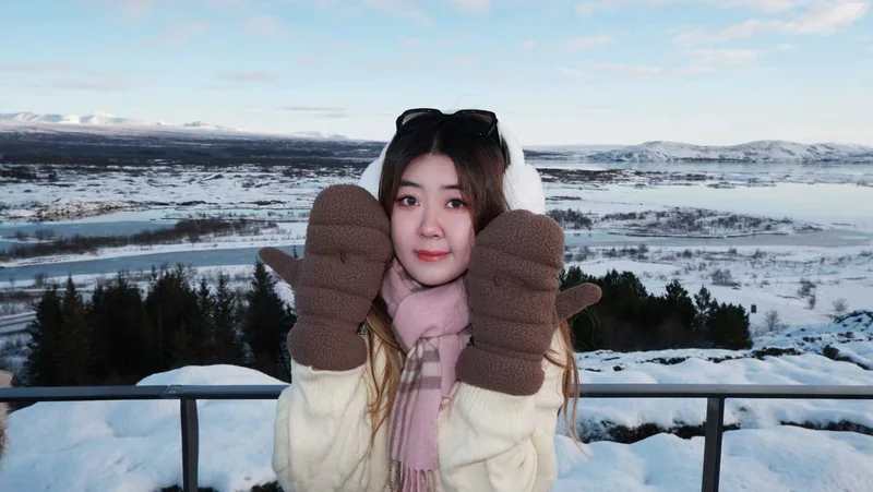 Anna smiling in a snowy landscape with warm mittens.