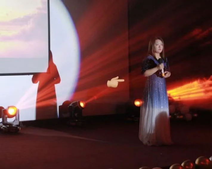 Anna singing on a warmly lit stage.